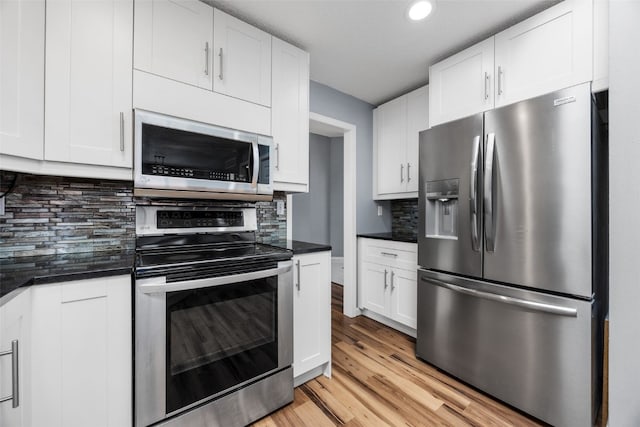 1125 Saint Andrews Dr, North Liberty, IA 52317 - kitchen featuring stainless steel appliances, dark countertops, light wood-style floors, white cabinetry, and recessed lighting