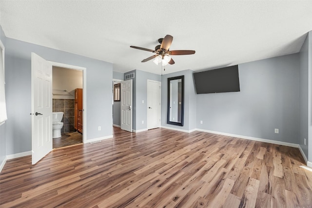 1125 Saint Andrews Dr, North Liberty, IA 52317 - unfurnished bedroom with wood finished floors, connected bathroom, and ceiling fan