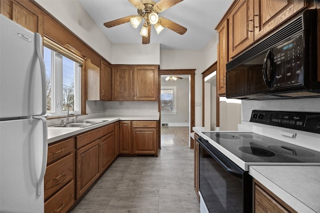 214 15th St NW, Cedar Rapids, IA 52405 - kitchen featuring freestanding refrigerator, electric range, black microwave, a ceiling fan, and brown cabinets