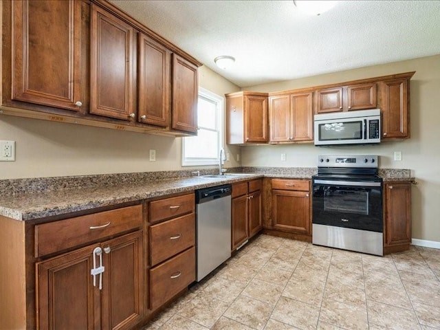 1175 F Ave, Marion, IA 52302 - kitchen featuring stainless steel appliances, brown cabinets, and dark countertops
