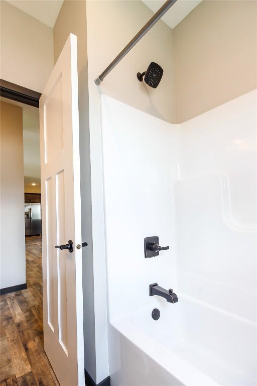 1600 Heartland St, Fairfax, IA 52228 - bathroom featuring shower / bathtub combination and wood finished floors