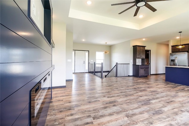 1600 Heartland St, Fairfax, IA 52228 - unfurnished living room with wood finished floors, a ceiling fan, a raised ceiling, and recessed lighting