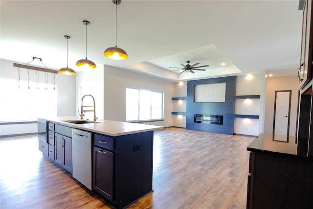 1600 Heartland St, Fairfax, IA 52228 - kitchen featuring stainless steel appliances, an island with sink, a raised ceiling, wood finished floors, and a ceiling fan