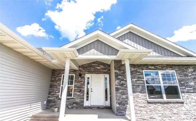 1600 Heartland St, Fairfax, IA 52228 - doorway to property with stone siding, board and batten siding, and covered porch