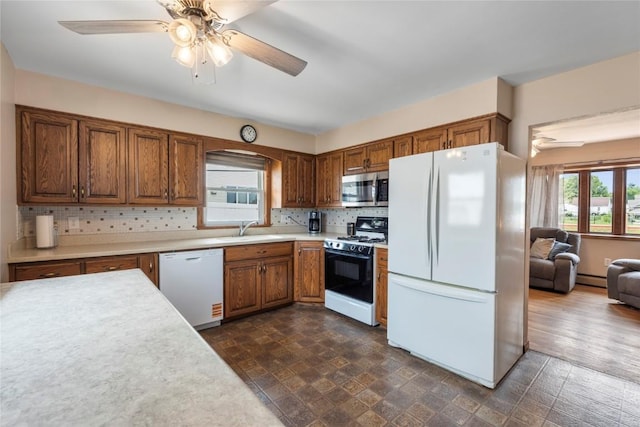 2469 1st St SW, Cedar Rapids, IA 52404 - kitchen featuring white appliances, ceiling fan, light countertops, and brown cabinets