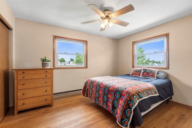 2469 1st St SW, Cedar Rapids, IA 52404 - bedroom featuring multiple windows, light wood-style floors, a baseboard heating unit, and a closet