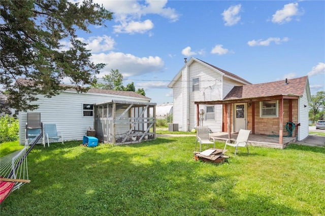 409 Railroad St, Fairfax, IA 52228 - back of property featuring a lawn, a shingled roof, and a sunroom
