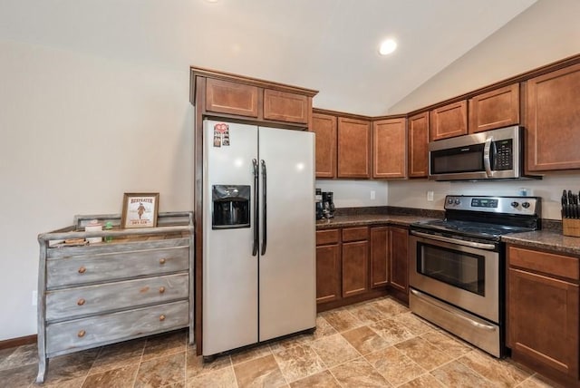5616 Dostal Dr SW, Cedar Rapids, IA 52404 - kitchen with appliances with stainless steel finishes, vaulted ceiling, stone finish flooring, brown cabinetry, and recessed lighting