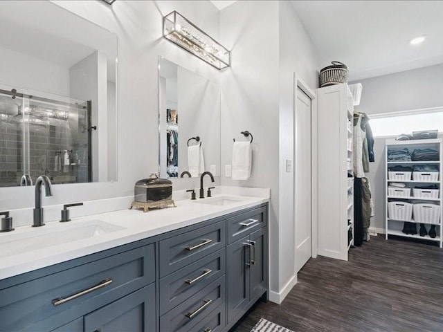 5112 Scenic View Ct SW, Cedar Rapids, IA 52404 - bathroom with a spacious closet, double vanity, a stall shower, and wood finished floors