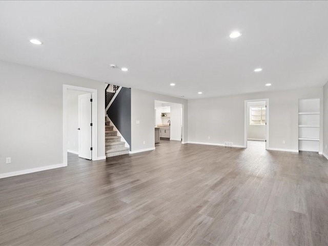 5112 Scenic View Ct SW, Cedar Rapids, IA 52404 - unfurnished living room featuring stairs, recessed lighting, and wood finished floors