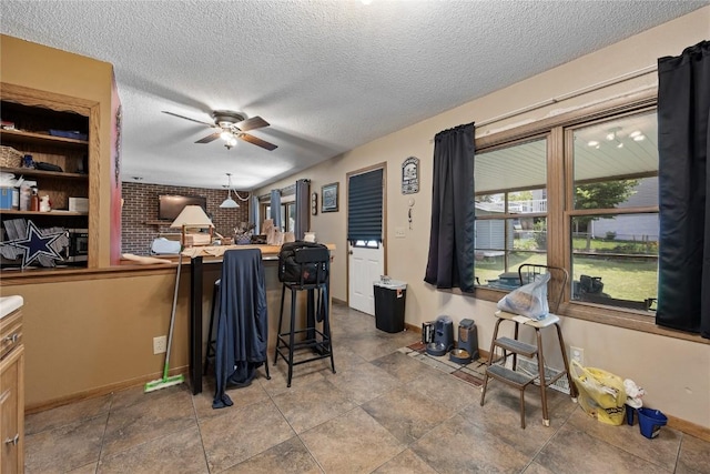 200 Drexel Dr SW, Cedar Rapids, IA 52404 - kitchen with ceiling fan, a textured ceiling, a breakfast bar, and a peninsula