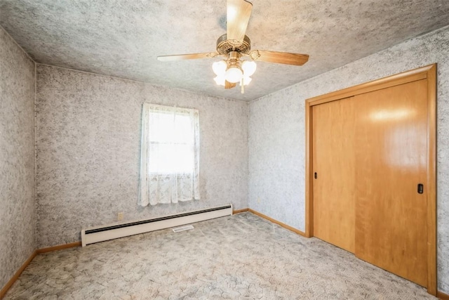 819 Valley St, Center Point, IA 52213 - unfurnished bedroom featuring a baseboard heating unit, carpet, a ceiling fan, and a closet