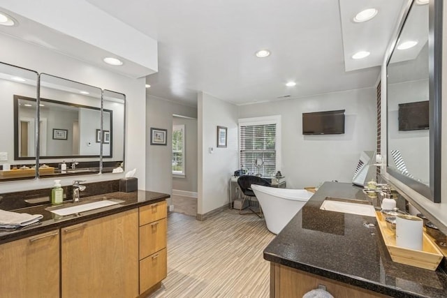 318 Ferson Ave, Iowa City, IA 52246 - bathroom with two vanities, a soaking tub, and recessed lighting