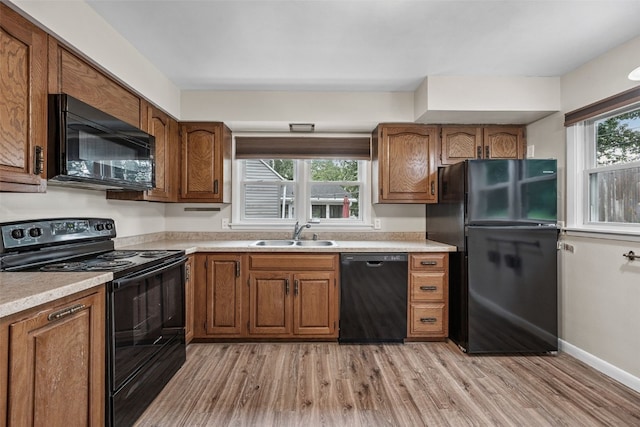 2539 Vernon Ct SE, Cedar Rapids, IA 52403 - kitchen featuring black appliances, brown cabinetry, and light countertops