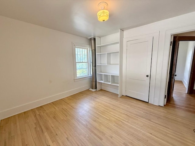 423 S 7th Ave, Iowa City, IA 52245 - unfurnished bedroom with baseboards and light wood-style floors