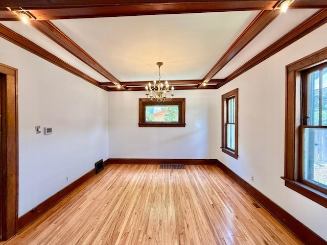 423 S 7th Ave, Iowa City, IA 52245 - spare room featuring plenty of natural light, a chandelier, light wood-style floors, beam ceiling, and ornamental molding