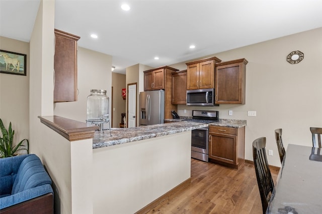 615 34th Ave, Marion, IA 52302 - kitchen with appliances with stainless steel finishes, wood finished floors, a peninsula, recessed lighting, and light stone countertops