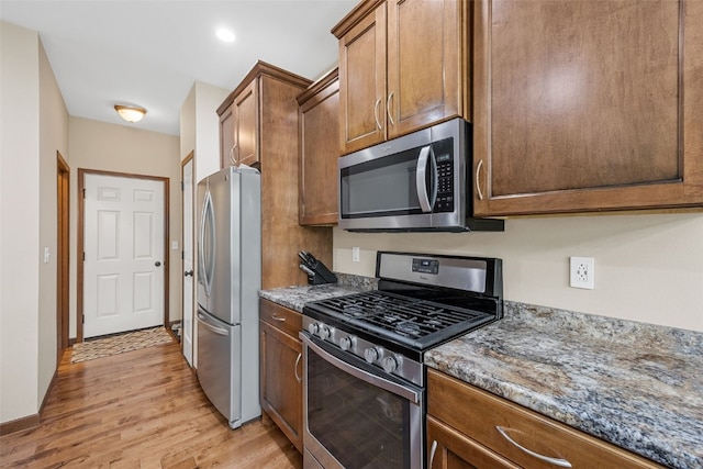 615 34th Ave, Marion, IA 52302 - kitchen featuring appliances with stainless steel finishes, light wood-style flooring, stone counters, brown cabinets, and recessed lighting