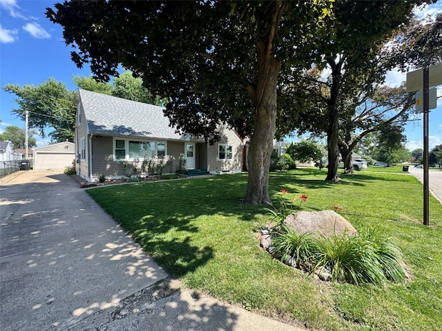 1175 28th St, Marion, IA 52302 - view of front of property featuring a shingled roof, a front lawn, a detached garage, and an outbuilding