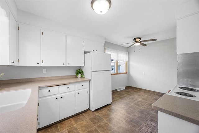 360 29th St NW, Cedar Rapids, IA 52405 - kitchen with white appliances, ceiling fan, white cabinetry, and stone finish flooring
