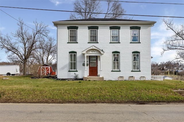 1860 E Ave NW, Cedar Rapids, IA 52405 - view of front of house featuring brick siding, a storage unit, and a front yard