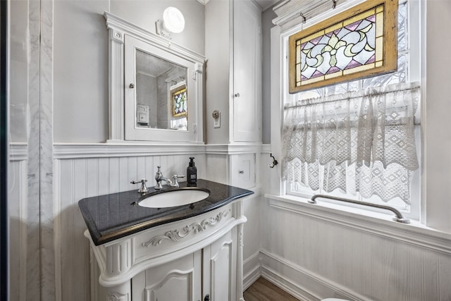 1860 E Ave NW, Cedar Rapids, IA 52405 - bathroom featuring vanity, healthy amount of natural light, and wainscoting