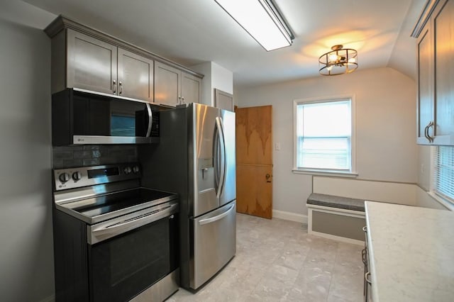 1135 Maplecrest Dr, Marion, IA 52302 - kitchen with appliances with stainless steel finishes, light countertops, lofted ceiling, and gray cabinetry