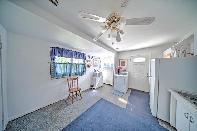 1011 Regent St NE, Cedar Rapids, IA 52402 - kitchen featuring washer / clothes dryer, ceiling fan, freestanding refrigerator, and light countertops