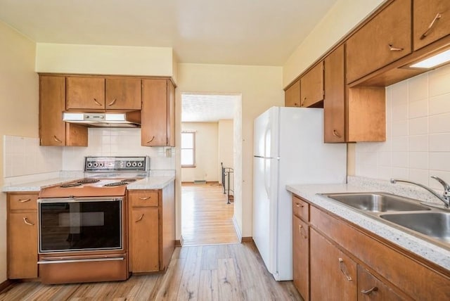 2029 Knollshire Rd NE, Cedar Rapids, IA 52402 - kitchen featuring range hood, white appliances, brown cabinetry, and light wood finished floors