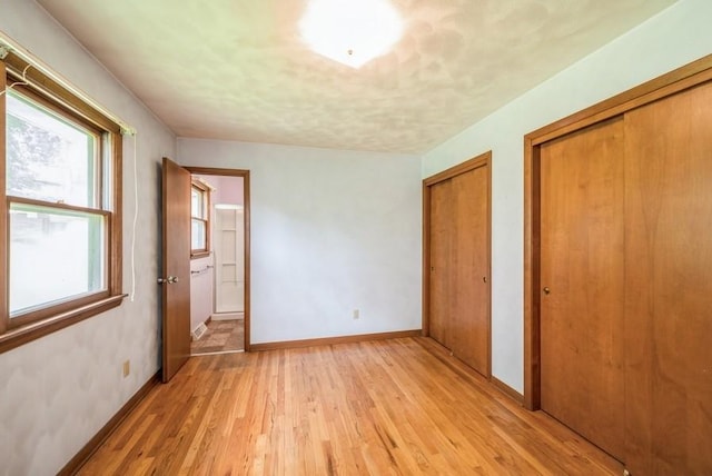 2029 Knollshire Rd NE, Cedar Rapids, IA 52402 - unfurnished bedroom featuring multiple closets and light wood finished floors