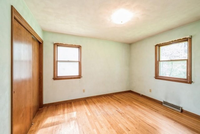 2029 Knollshire Rd NE, Cedar Rapids, IA 52402 - unfurnished bedroom with light wood finished floors, multiple windows, and a closet