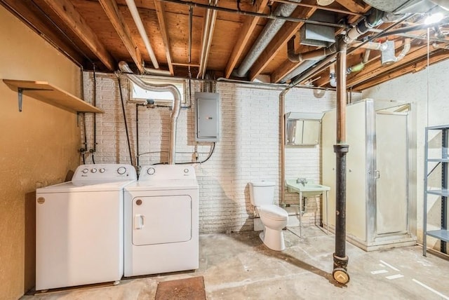 2029 Knollshire Rd NE, Cedar Rapids, IA 52402 - laundry room featuring electric panel, independent washer and dryer, and brick wall