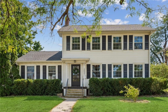 2021 Bever Ave SE, Cedar Rapids, IA 52403 - colonial inspired home featuring a chimney and a front yard