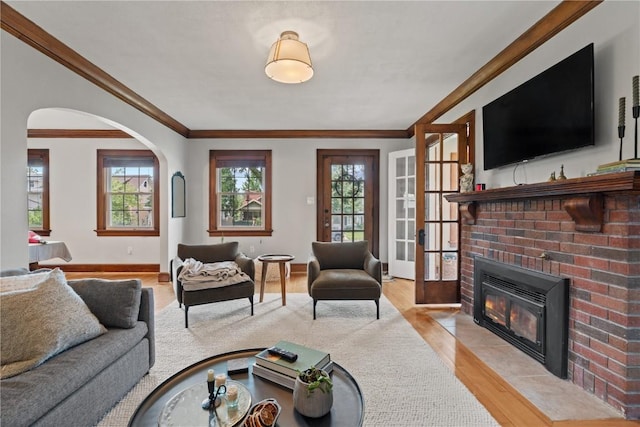 2021 Bever Ave SE, Cedar Rapids, IA 52403 - living room featuring crown molding, a fireplace, arched walkways, and light wood-style floors