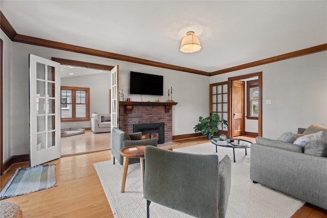2021 Bever Ave SE, Cedar Rapids, IA 52403 - living room with light wood-style flooring, a fireplace, french doors, and crown molding
