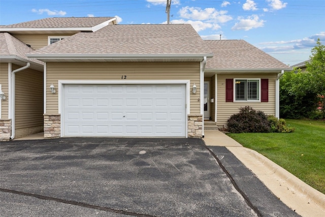 1458 Tower Ln NE Unit 12, Cedar Rapids, IA 52402 - view of front of home featuring stone siding, driveway, a garage, roof with shingles, and a front yard