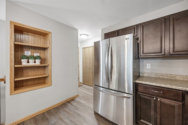 1458 Tower Ln NE Unit 12, Cedar Rapids, IA 52402 - kitchen with freestanding refrigerator, dark brown cabinets, light wood-style flooring, and light countertops