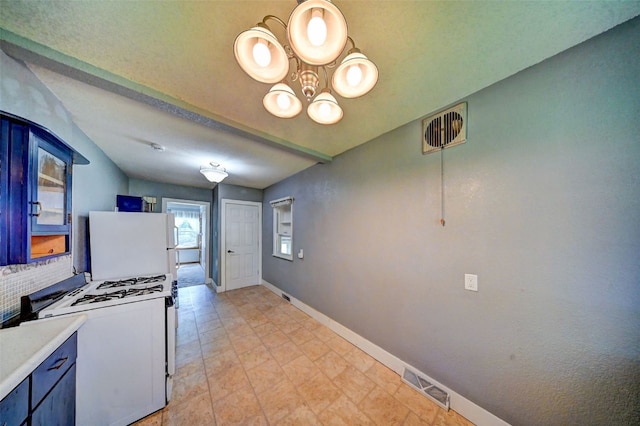 336 20th St NW, Cedar Rapids, IA 52405 - kitchen with white appliances, blue cabinetry, a chandelier, and light countertops