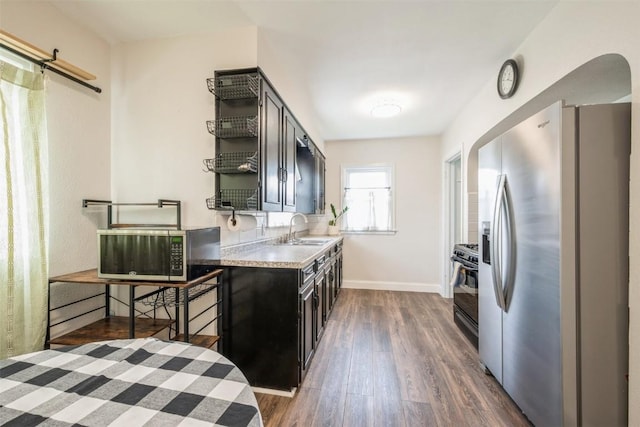2000 Hamilton St SW, Cedar Rapids, IA 52404 - kitchen with stainless steel fridge with ice dispenser, open shelves, dark wood finished floors, black gas range, and light countertops