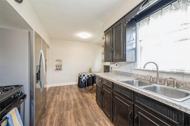 2000 Hamilton St SW, Cedar Rapids, IA 52404 - kitchen featuring gas stove, dark wood finished floors, light countertops, and dark brown cabinets
