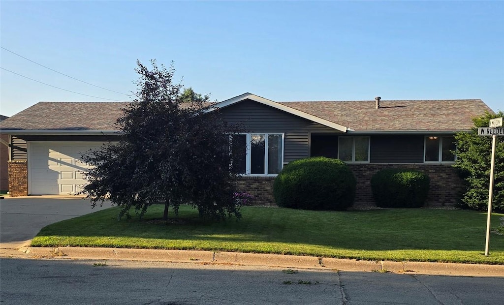 300 W Reeder, Mechanicsville, IA 52306 - ranch-style home with brick siding, concrete driveway, and a front yard