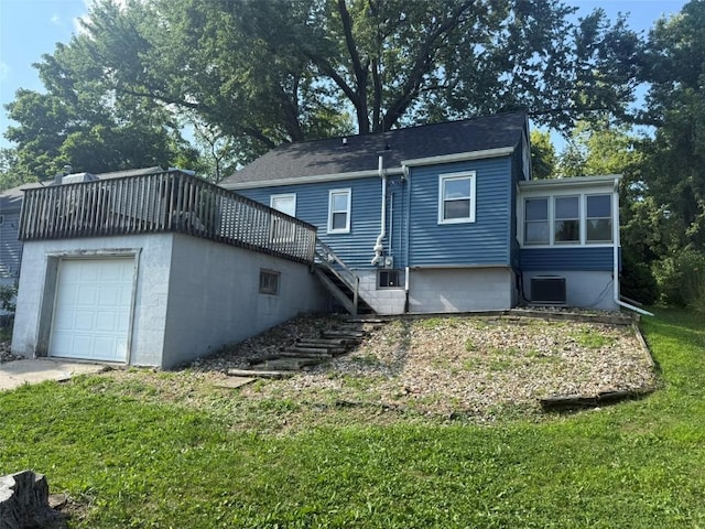 1839 K Ave NE, Cedar Rapids, IA 52402 - rear view of house featuring stairway, a garage, a yard, and an outbuilding