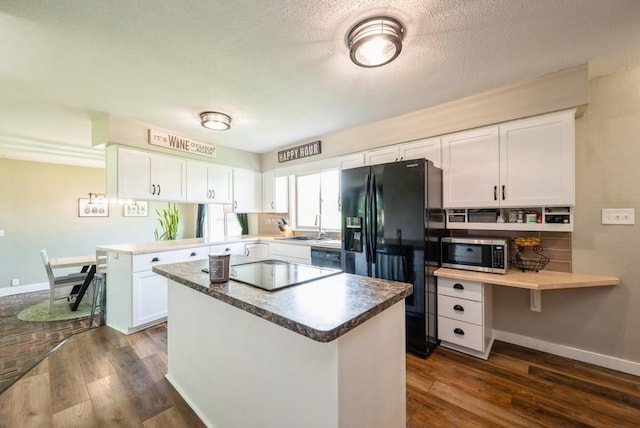 1935 1st Ave SW, Cedar Rapids, IA 52405 - kitchen with black appliances, dark wood finished floors, a peninsula, white cabinets, and a textured ceiling