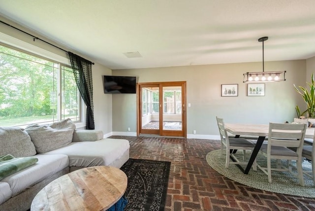 1935 1st Ave SW, Cedar Rapids, IA 52405 - living room featuring brick flooring, healthy amount of natural light, and a chandelier