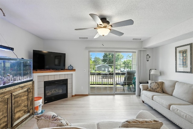 3060 Wilson Ave SW Unit 7, Cedar Rapids, IA 52404 - living room featuring wood finished floors, a textured ceiling, a fireplace, and a ceiling fan
