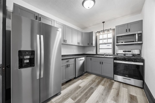 1818 Park Ave SE, Cedar Rapids, IA 52403 - kitchen with gray cabinets, appliances with stainless steel finishes, light wood-style flooring, and a textured ceiling