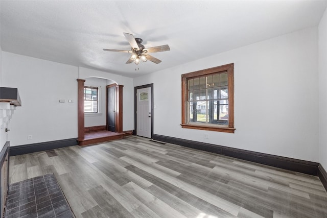 1818 Park Ave SE, Cedar Rapids, IA 52403 - unfurnished living room with arched walkways, ceiling fan, and wood finished floors