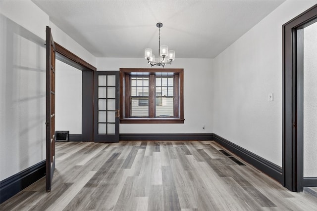 1818 Park Ave SE, Cedar Rapids, IA 52403 - unfurnished room with a chandelier and wood finished floors