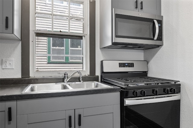 1818 Park Ave SE, Cedar Rapids, IA 52403 - kitchen with black gas range, stainless steel microwave, dark countertops, and a textured wall