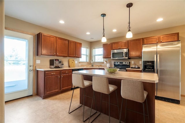 6045 Ridgewood Meadows Ln NE, Cedar Rapids, IA 52411 - kitchen with appliances with stainless steel finishes, recessed lighting, pendant lighting, a center island, and brown cabinetry